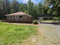 Traditional home boasts a covered parking area and lush green space surrounded by trees at 3405 Ode Turner Rd, Hillsborough, NC 27278