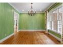 Formal dining room featuring hardwood floors, decorative chandelier, and large windows at 3509 Carlton Square Pl, Raleigh, NC 27612