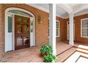 Inviting front porch with brick flooring and a beautiful wooden front door with sidelights at 3509 Carlton Square Pl, Raleigh, NC 27612