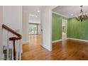 Hallway with hardwood floors, white trim, and open access to rooms with natural light at 3509 Carlton Square Pl, Raleigh, NC 27612