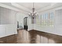 Elegant dining room boasting hardwood floors, wainscoting, and a statement chandelier at 3908 Chaumont Dr, Apex, NC 27539