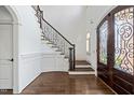 Grand foyer with hardwood floors, staircase with iron railings, and decorative front door at 3908 Chaumont Dr, Apex, NC 27539