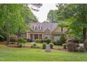 Charming brick home features a manicured lawn and lush landscaping with a welcoming front porch at 504 Belmont Cir, Wake Forest, NC 27587
