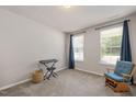 Well-lit bedroom with neutral walls, carpeted floors, and two windows with views of the outdoors at 6512 Blalock Forest Dr, Willow Springs, NC 27592