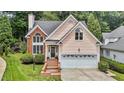 This lovely home boasts a 2-car garage and an arched window above the brick entryway at 6728 Pointe Vista Cir, Raleigh, NC 27615