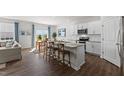 Open-concept kitchen with an island, stainless steel appliances, and a seamless flow into the dining and living areas at 708 Comice Pear Way, Willow Springs, NC 27592