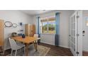 Bright office space with a large window, wood floors, and stylish decor, creating a perfect workspace at 708 Comice Pear Way, Willow Springs, NC 27592