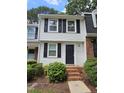 Charming two-story townhome with black shutters, brick stairs, and lush green landscaping at 7719 Kingsberry Ct, Raleigh, NC 27615