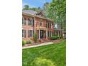 Side view of a brick home featuring a well-kept lawn and traditional architectural details at 8 Pine Top Pl, Durham, NC 27705