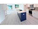 Bright, open kitchen with a blue island and white cabinetry at 1003 Regalia Rd # 33, Durham, NC 27713