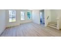 Bright living room with three windows and light wood floors at 1003 Regalia Rd # 33, Durham, NC 27713