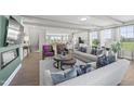 Open-concept living space with abundant natural light, stylish furnishings, and a view into the kitchen at 101 Ailey Brook Way # 200, Wake Forest, NC 27587
