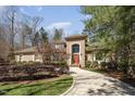 Beautiful brick home with well-manicured landscaping, long driveway, and red front door at 10210 Governors Drive Dr, Chapel Hill, NC 27517