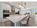 Open concept kitchen features an eat-in island with white cabinets and stainless steel appliances at 103 Ailey Brook Way # 200, Wake Forest, NC 27587