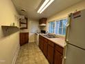 Functional kitchen features a double sink beneath a window, and cabinetry at 1202 Kilby St, Burlington, NC 27215