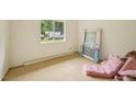 Bright bedroom with a large window offering serene view, primed for renovation with bare walls and floors at 1407 Arnette Ave, Durham, NC 27707