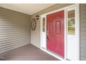 Close-up of the front door featuring a charming round window and side lights at 1601 Balkan Rd, Fuquay Varina, NC 27526