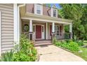 Inviting front porch, red door, round window, and beautiful landscaping at 1601 Balkan Rd, Fuquay Varina, NC 27526