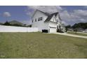 A white, two-story home is framed by a green yard and a white fence at 170 Kinsale Ct, Garner, NC 27529
