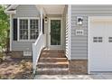 View of the welcoming front entrance with brick steps, gray siding, and modern lighting at 1801 Sagamore Ct, Raleigh, NC 27604