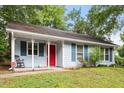A quaint home with light blue siding, a cozy front porch and a vibrant red door at 2 Capri Ter, Durham, NC 27703