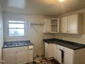 This kitchen features white cabinets, sink, and window at 2302 Chautauqua Ave, Durham, NC 27707