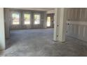 Bright unfinished living room awaits conversion with windows and smooth concrete flooring at 245 Tidal Pool Way, Cary, NC 27519