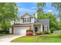 Landscaped front yard with a two-car garage and charming exterior details at 248 Inkster Cv, Raleigh, NC 27603