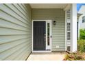 Inviting front door with sidelight, black hardware, and stylish exterior lighting at 248 Inkster Cv, Raleigh, NC 27603