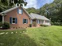 Attractive brick home with blue shutters, manicured landscaping, and a well-maintained lawn at 3110 Fieldstone Ln, Mebane, NC 27302