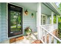 Inviting front porch with a decorative pineapple theme and a quaint outdoor light fixture at 318 Fieldstone Dr, Burlington, NC 27215