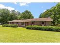 Charming brick home with large windows and lush landscaping on a sunny day at 462 Sullivan Rd, Selma, NC 27576
