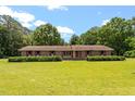 Classic brick ranch-style home featuring a large, manicured lawn and mature trees at 462 Sullivan Rd, Selma, NC 27576