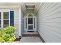 Exterior front door view of a well maintained house with a lovely welcome mat and landscaping at 6 Danesfield Ct, Durham, NC 27707