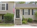 Close-up of the front door, featuring a black door, stairs, and an American flag at 6927 Beaverwood Dr Dr, Raleigh, NC 27616
