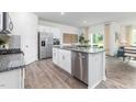 Well-lit kitchen with white cabinets, stainless steel appliances, granite countertops and a large island at 709 Comice Pear Way, Willow Springs, NC 27592