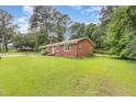 Traditional brick home featuring a well-maintained lawn and mature trees providing ample shade at 9751 N Highway 96, Selma, NC 27576