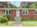 Close-up of the brick home's front door, showcasing the brick facade and small front steps at 9751 N Highway 96, Selma, NC 27576