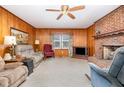 Cozy living room with wood paneling, a brick fireplace, and comfortable seating arrangement at 9751 N Highway 96, Selma, NC 27576