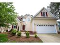 Charming two-story home features a well-manicured lawn, attached two-car garage, and inviting red front door at 10 London Way, Spring Lake, NC 28390