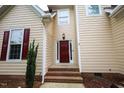 Inviting entrance with a red front door, brick steps, and decorative window, creating a welcoming curb appeal at 10 London Way, Spring Lake, NC 28390