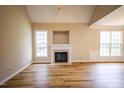 Spacious living room featuring vaulted ceilings, a fireplace, and large windows for ample natural light at 10 London Way, Spring Lake, NC 28390