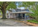 Rear of a home with a screened-in porch and a carport, surrounded by lush trees at 102 W Weatherspoon St, Sanford, NC 27330