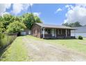Inviting brick home featuring a detached garage and a charming covered front porch at 107 Rencher St, Hillsborough, NC 27278