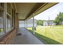 A covered porch with brick accents and a view of the surrounding neighborhood at 107 Rencher St, Hillsborough, NC 27278
