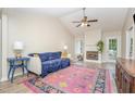 Cozy living room with vaulted ceilings, a fireplace, hardwood floors, and abundant natural light at 110 Oak Park Dr, Benson, NC 27504