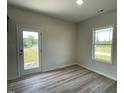 The dining room area features lovely wood flooring, a bright window, and access to the backyard at 111 Bonsai Way, Four Oaks, NC 27524