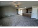 Open-concept living space with carpeted living room and open access to the kitchen at 111 Coharie Dr, Lillington, NC 27546