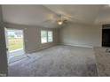 Bright living room featuring plush carpeting, vaulted ceilings, and ample natural light at 111 Coharie Dr, Lillington, NC 27546