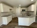 Modern kitchen features white cabinets, granite countertops, and stainless steel appliances at 111 Mahogany Way, Four Oaks, NC 27524